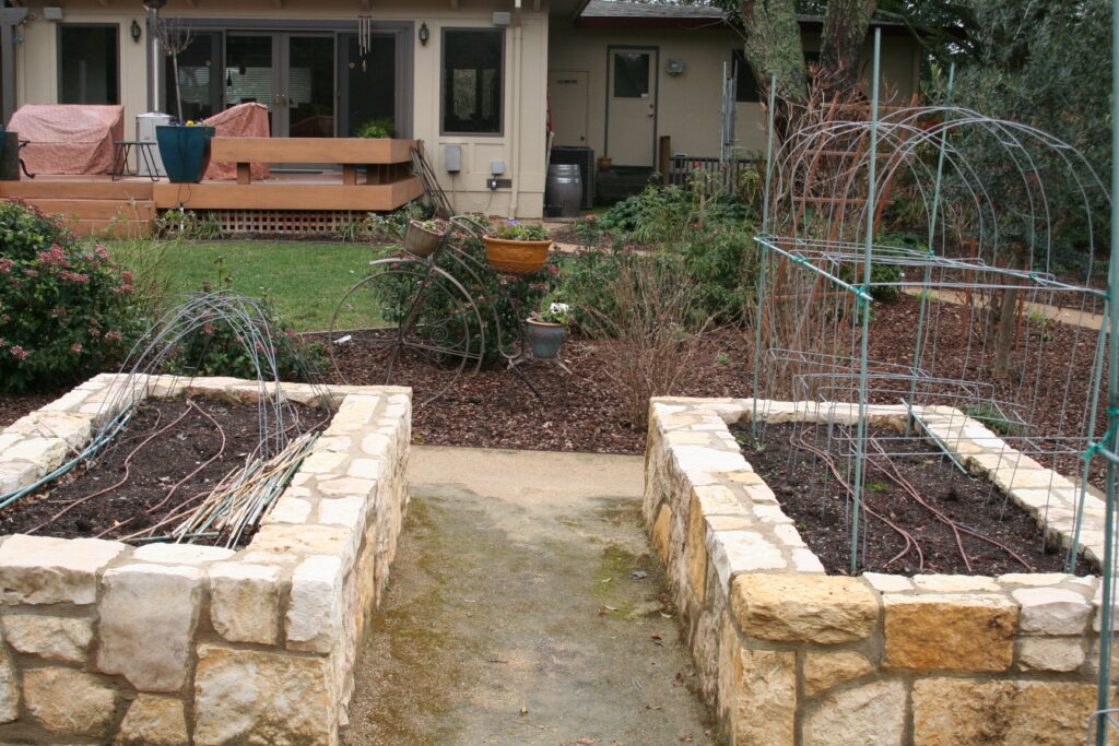 two raised planters in a private Santa Rosa residence's backyard; the planters have cut stone veneer