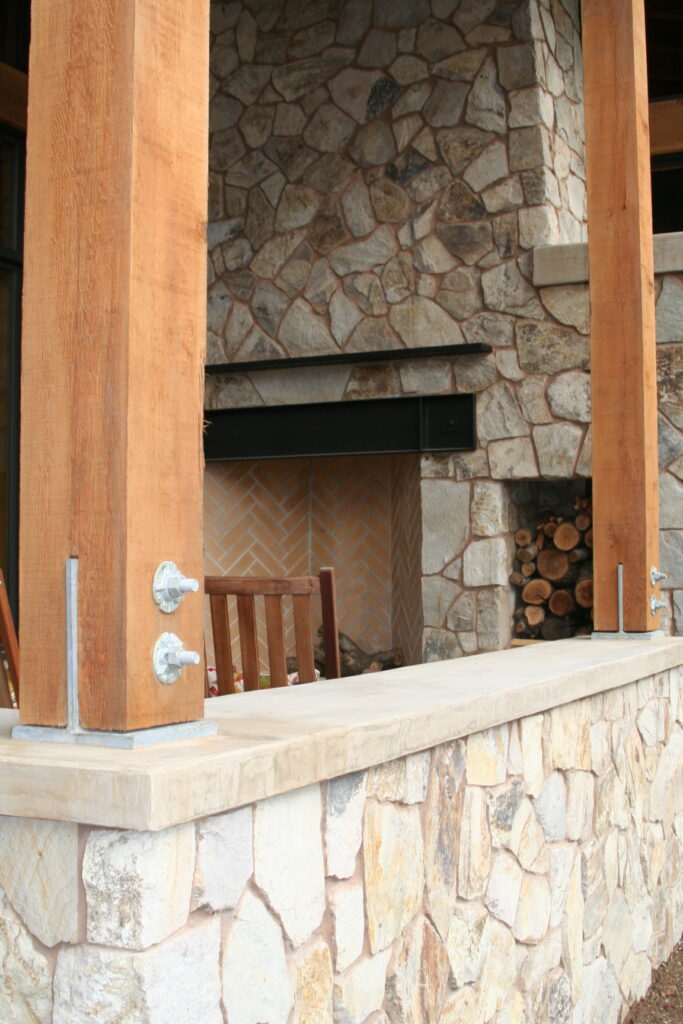 closeup of the cut stone veneer surrounding the walls of a winery's outdoor patio; the roof is supported by beautiful red wood beams and exposed hardware