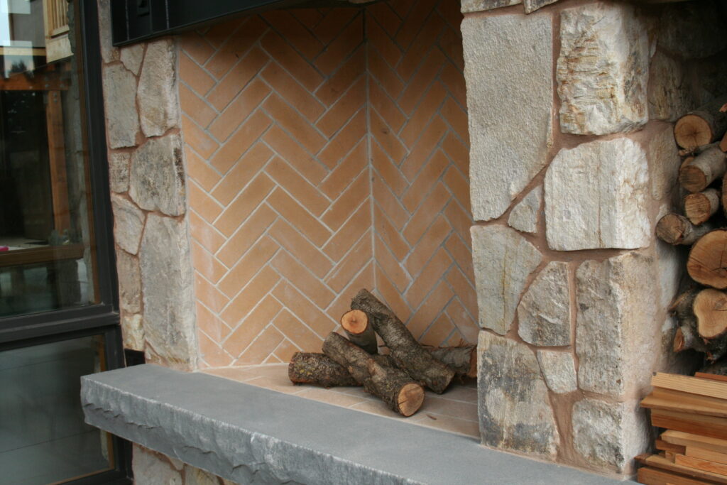 closeup of the interior of an outdoor fireplace; the interior of the fireplace features bricks laid in a herringbone pattern