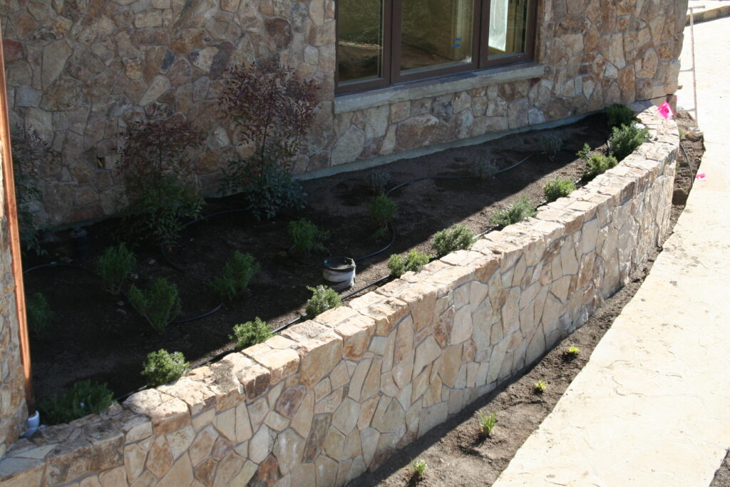 exterior of a building features seamless cut stone veneer that matches the garden planters just outside the building