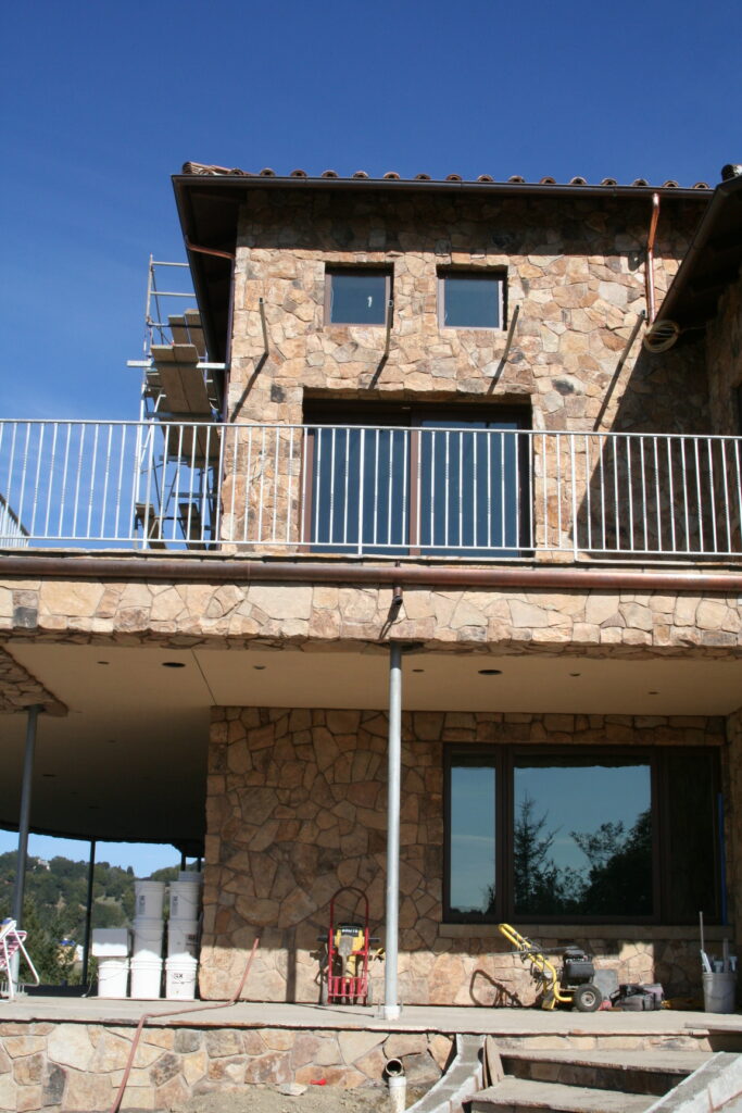 the team at Masonry by Conrad works on the cut stone veneer for a Santa Rosa estate high up in the hills; both the first and second floor of the estate feature the stone veneer