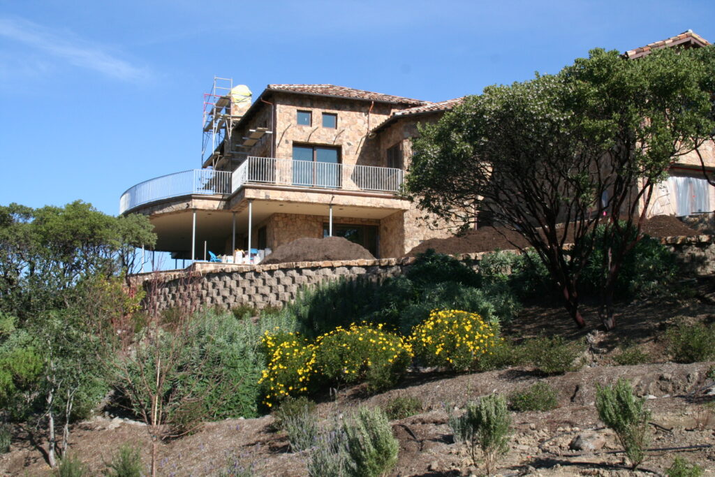 the team at Masonry by Conrad works on the cut stone veneer for a Santa Rosa estate high up in the hills; the estate is surrounded on this side by its tiered garden