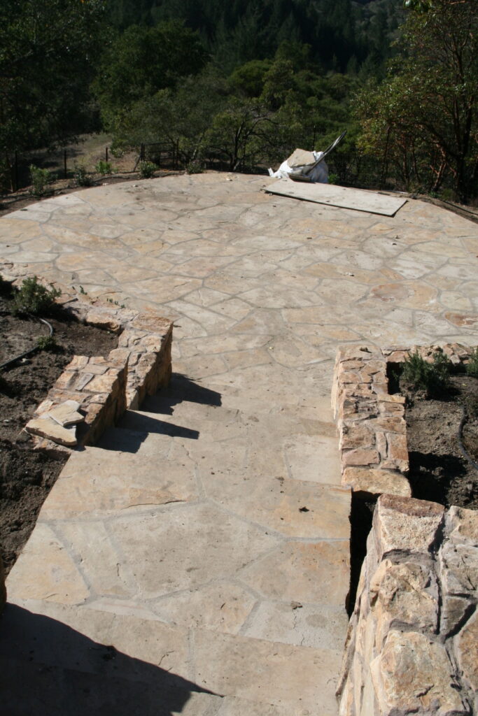 hardscape landscaping project recently completed by Masonry by Conrad; the stone patio in the center is surrounded by yet unfinished landscaping