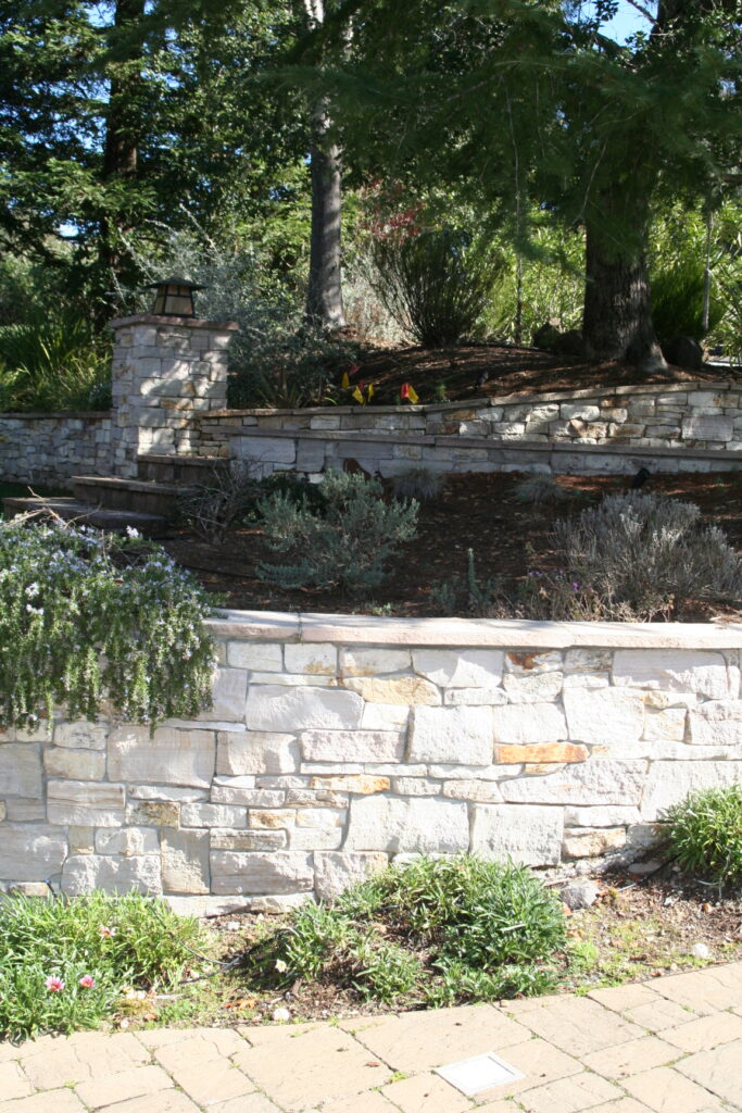 cut stone veneer retaining wall for a tiered front yard landscape