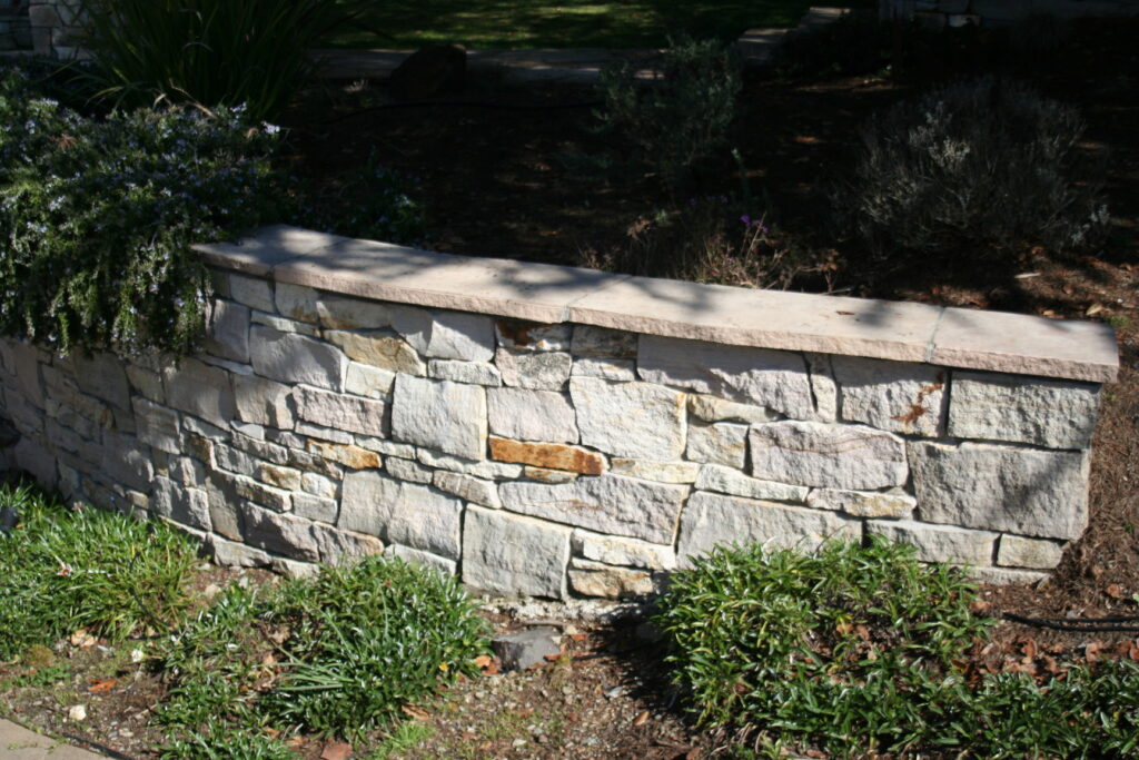 cut stone veneer retaining wall for a tiered front yard landscape