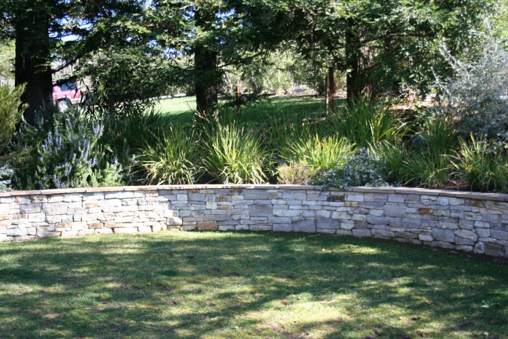 cut stone veneer retaining wall for a tiered front yard landscape