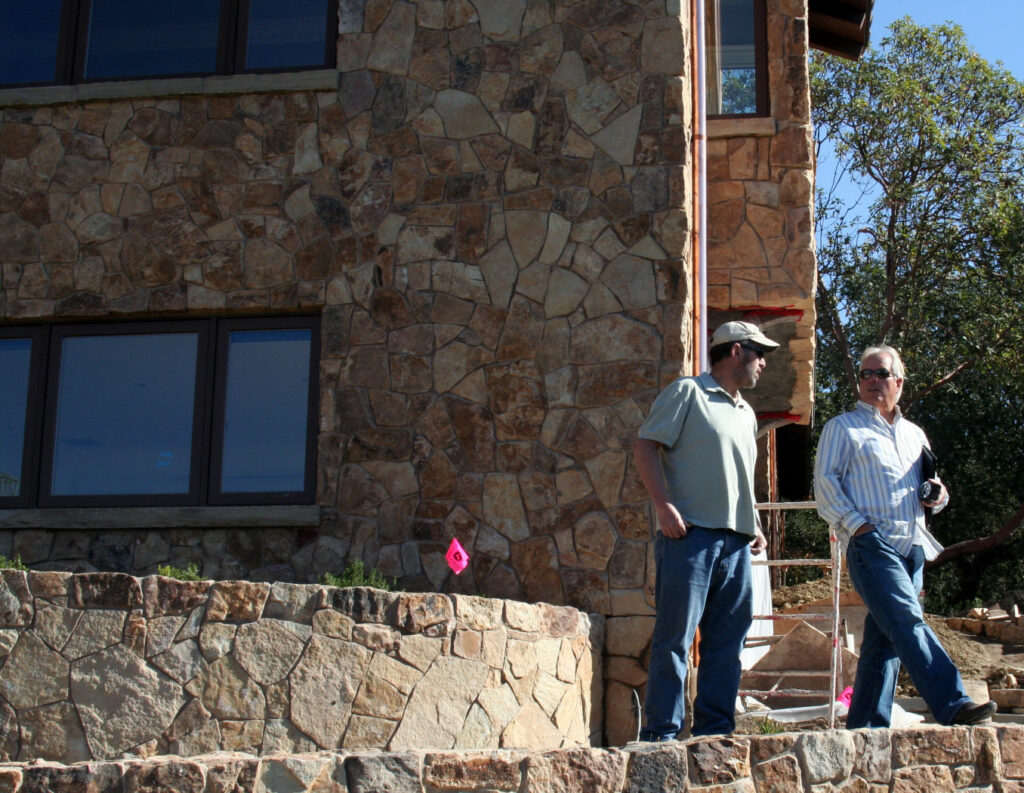 Conrad and his client stand on one of the garden tiers overlooking the recently completed masonry project