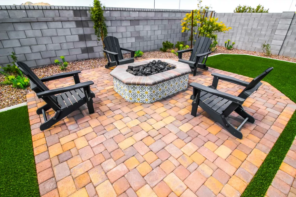 beautiful outdoor conversation firepit on a paver patio surrounded by four black wooden lawn chairs